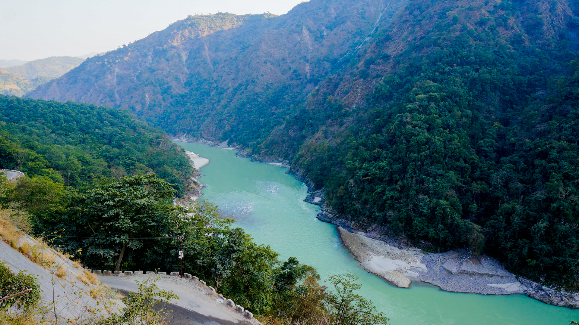 Turquoise river running through a steep forested mountain gorge