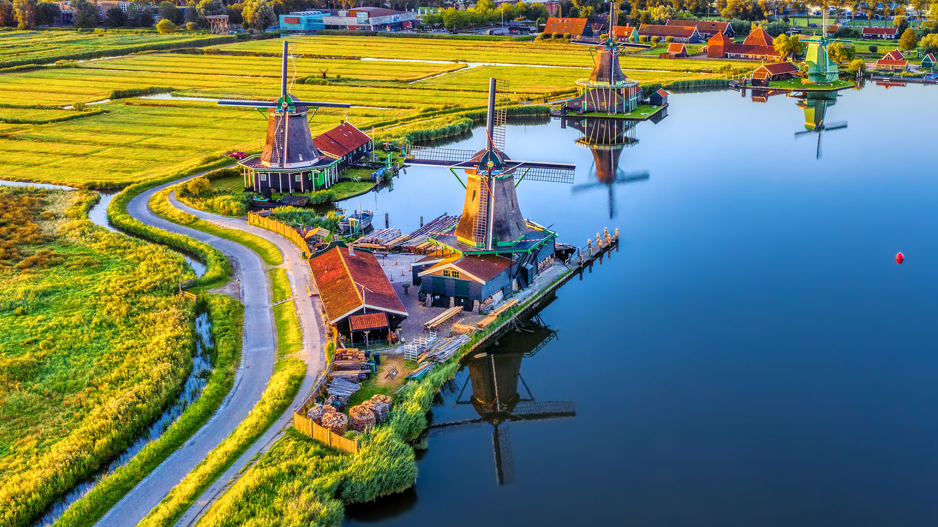 Windmills and green wooden houses beside the water at Zaanse Schans, Netherlands