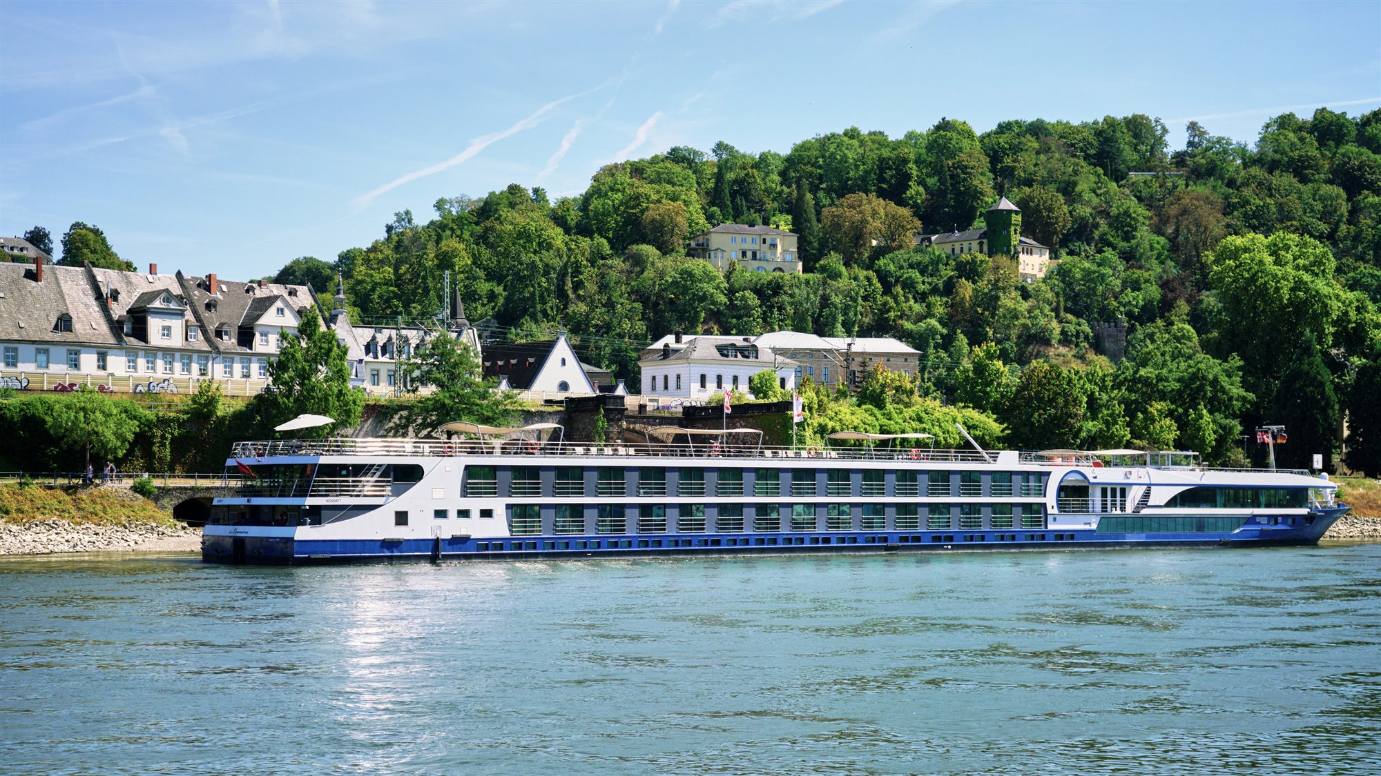 Rhine river cruise view of a hilltop castle above terraced vineyards